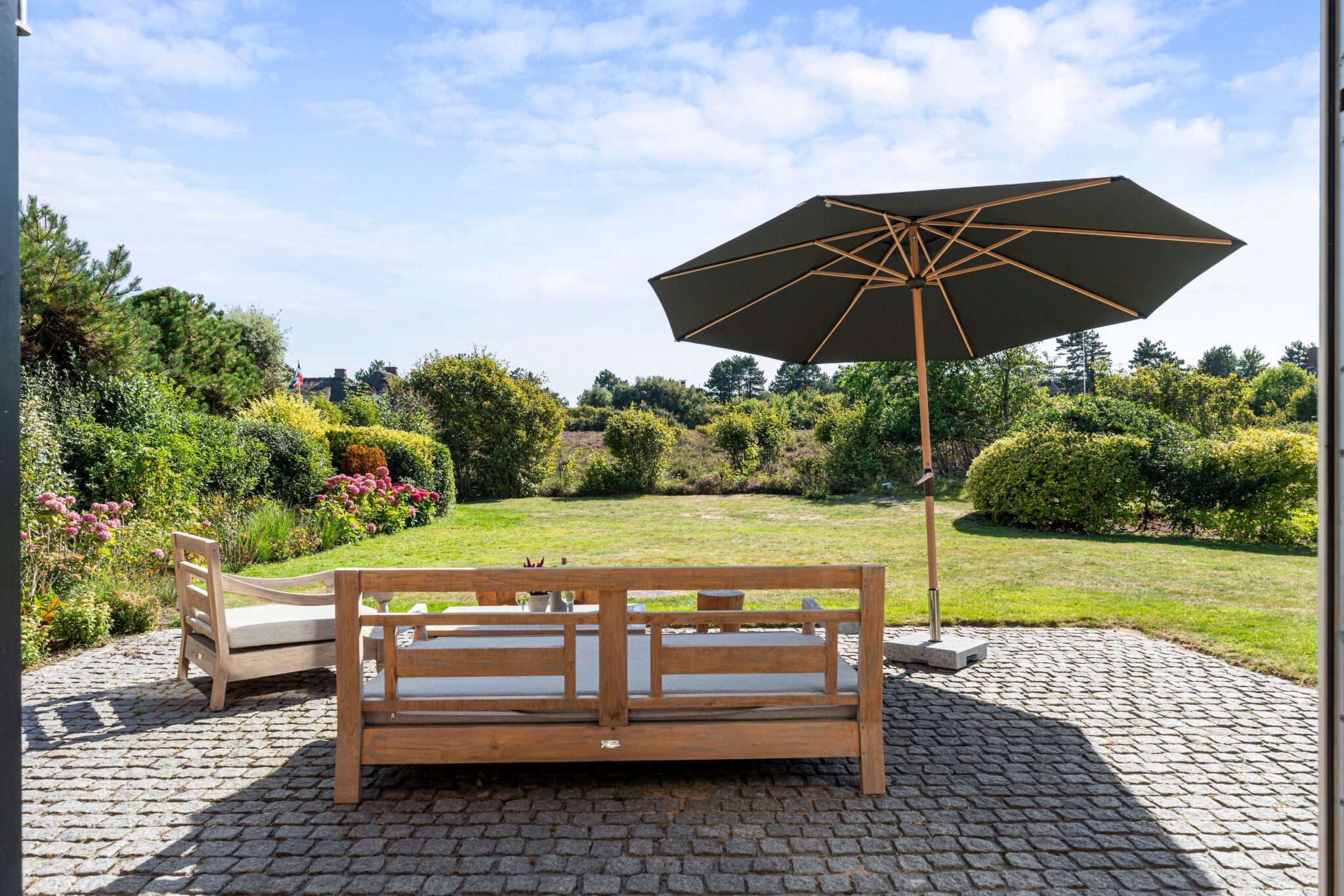 Terrasse mit Sonnenschirm und Gartenmöbel